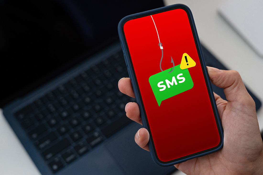 A smartphone screen displays a red background with a hook going down to a green SMS text message icon that has a yellow hazard icon in the top right hand corner.