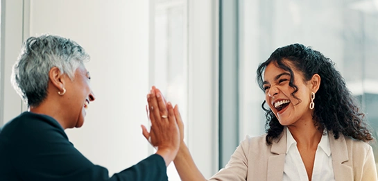 Two professionals high‑fiving indoors