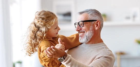 Older adult holding a young child indoors