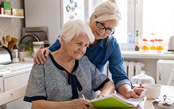 Aging mother and daughter reviewing paperwork