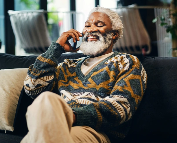 Older adult sitting indoors holding a phone