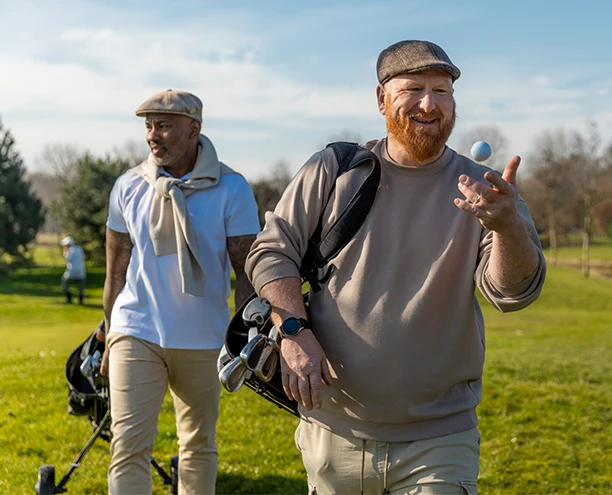 Two adults walking outdoors together on a golf course