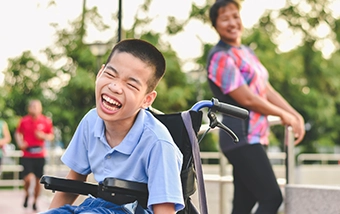 Child using a wheelchair while playing outdoors