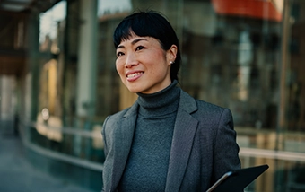 Professional woman walking outside holding a tablet